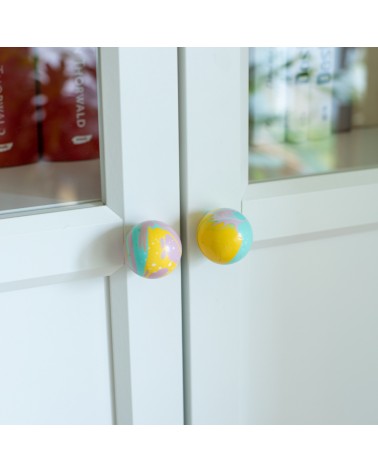 Bouton de meuble en bois de hêtre jaune funky poignée design vue inclinée monté sur une porte semi-vitrée