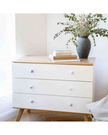 Bouton de meuble en bois de hêtre aubergine poignée design installé sur une commode blanche surmontée d'une plante en pot