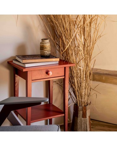 Bouton de meuble en bois de hêtre rouge cerise poignée design installé sur un meuble en bois avec des fleurs séchées