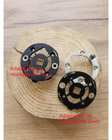 Deux adaptateurs de montage rapide pour les poignées de porte vu de face, posé sur une table en bois