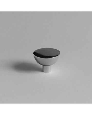 Bouton de meuble chrome poli LUNA M posée sur une surface grise