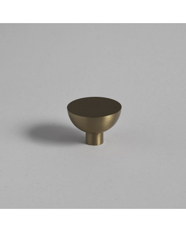 Bouton de meuble or mat LUNA M poignée design posée sur une surface plane avec un arrière-plan uniforme