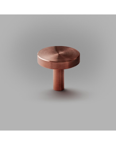 Bouton de meuble en laiton NENA M poignée design posée sur une surface plane