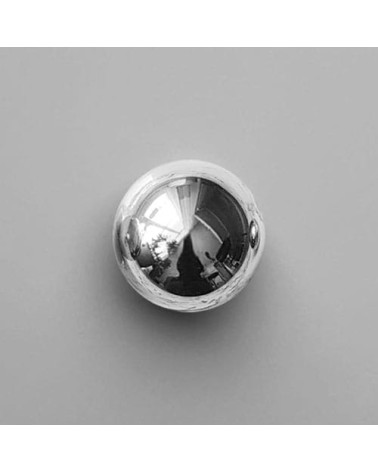 Bouton de meuble chrome poli ODETE M poignée design posée sur une surface grise