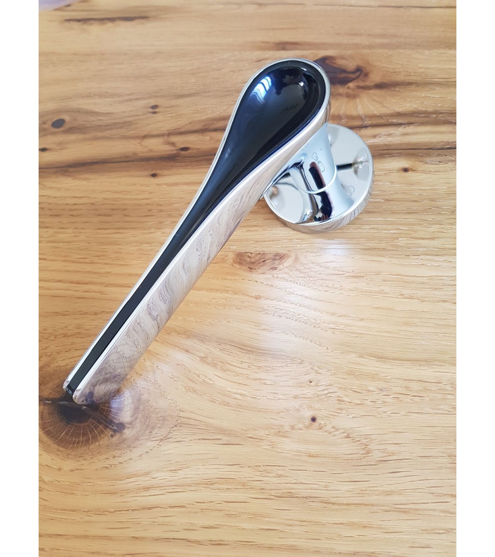 poignee bicolore chrome polie et noire sur une table en bois