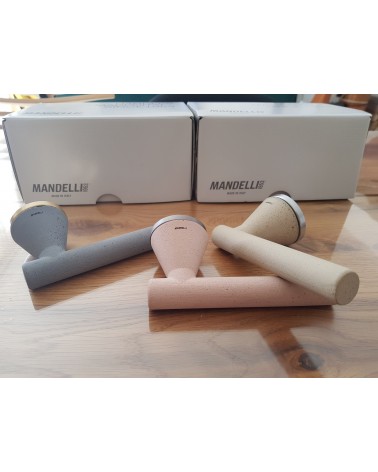 Poignée de porte futuriste Mandelli Juno poignée design trois couleur posée sur une table fond packaging