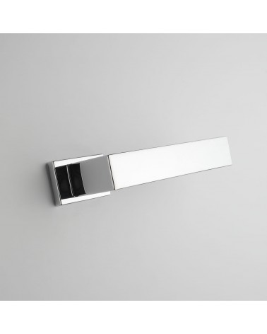Poignée de porte chrome poli PINA poignée design vue de bas inclinée montée sur une porte