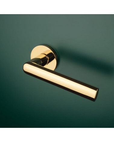 Poignée de porte or poli SILENA quincaillerie design montée sur une porte