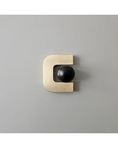 Poignée de meuble or poli ISA XS poignée design avec une sphère noire placée à l'intérieur de l'ouverture