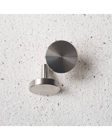 Bouton de meuble chrome poli NENA M poignée design posée sur une surface en ciment