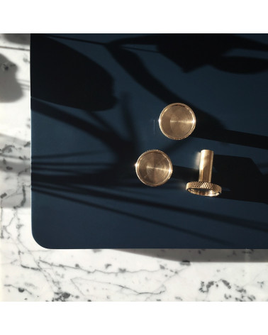 Bouton de meuble en laiton VERA poignée design posée sur une table noire