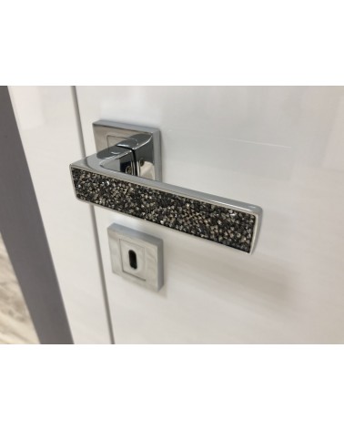 Poignée de porte zamak GLAMOUR quincaillerie design couleur 1 vue inclinée montée sur une porte
