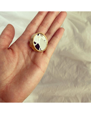 Bouton de meuble en laiton et Terrazzo poignée design présenté sur une main