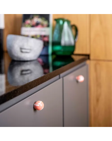 Bouton de meuble en bois de hêtre rouge cerise poignée design installé sur une porte de meuble de cuisine