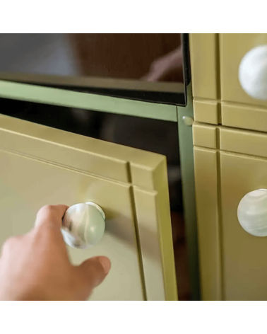 Bouton de meuble en bois de hêtre Mistel poignée design fixé sur une porte ouverte tenue par une main