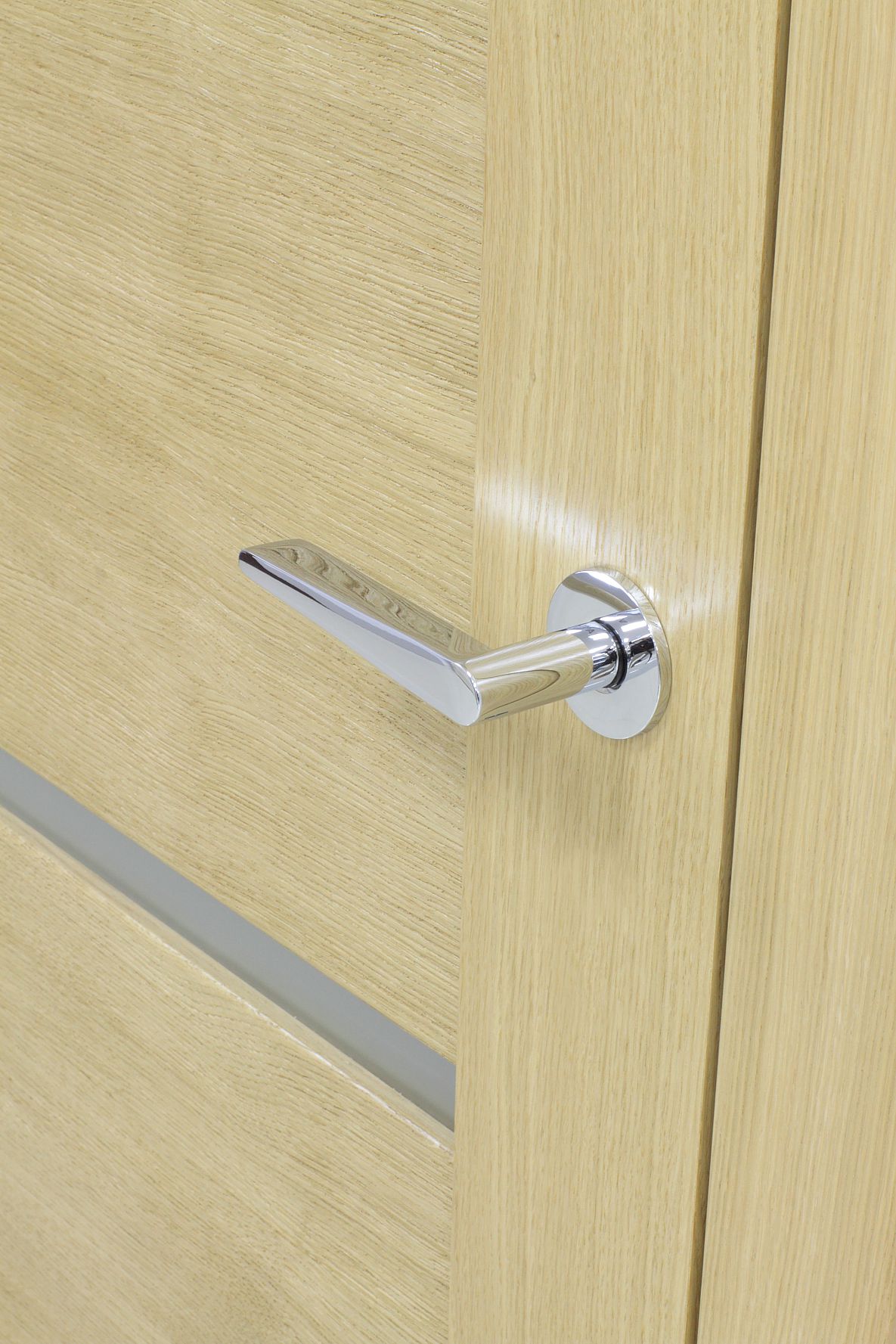 poignéede porte intérieure chromée sur une porte en bois clair