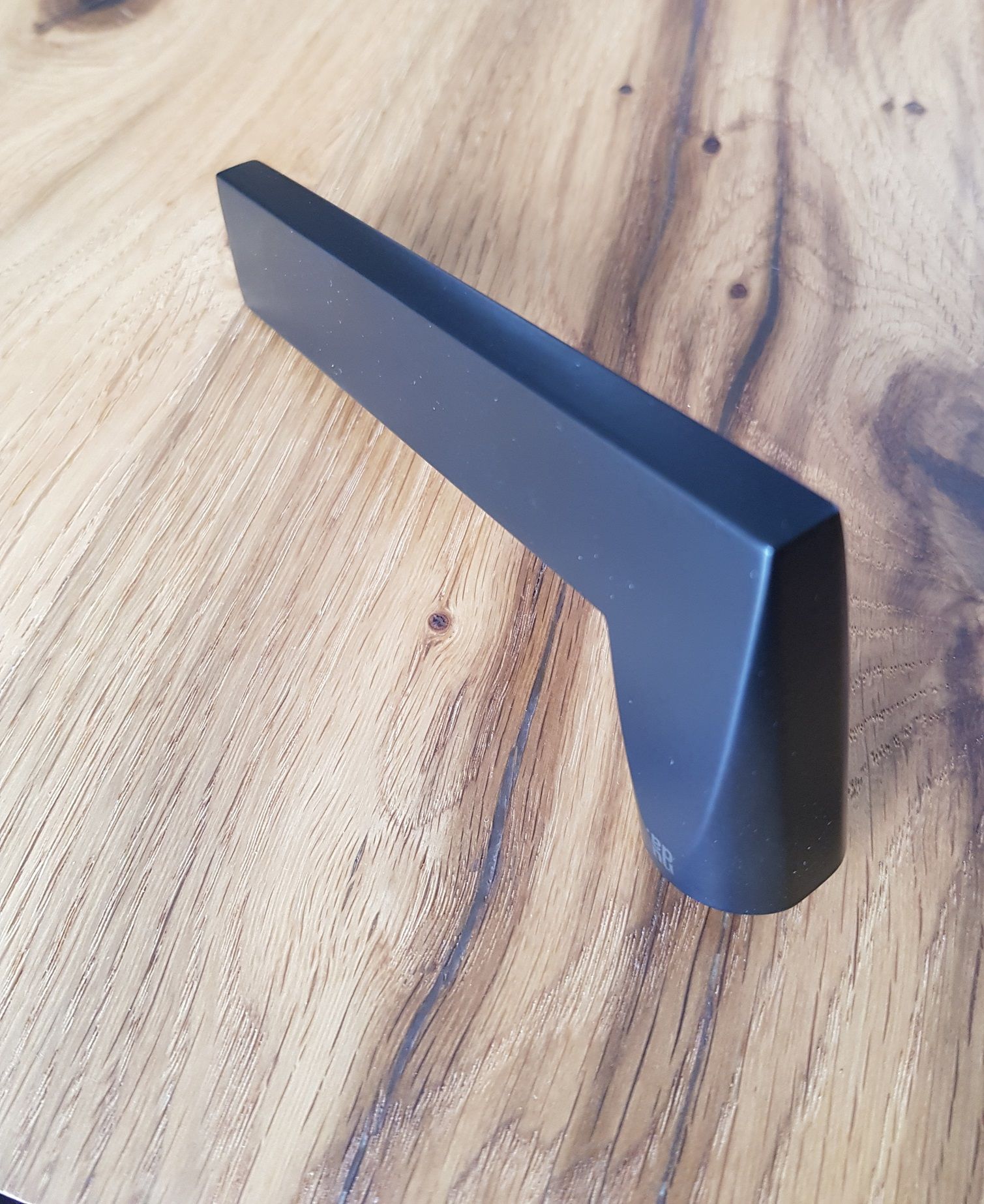 Poignée de porte noire futuriste sur une porte en bois aspect chêne, un look tendance