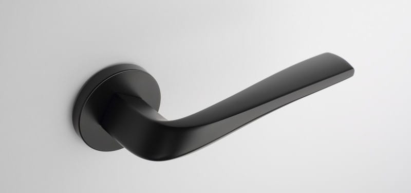 Poignée de porte design noir sur une plaque ronde aux formes voluptueuse