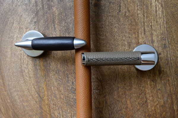 poignées pour porte battante avec béquille en cuir installée sur porte en bois foncé