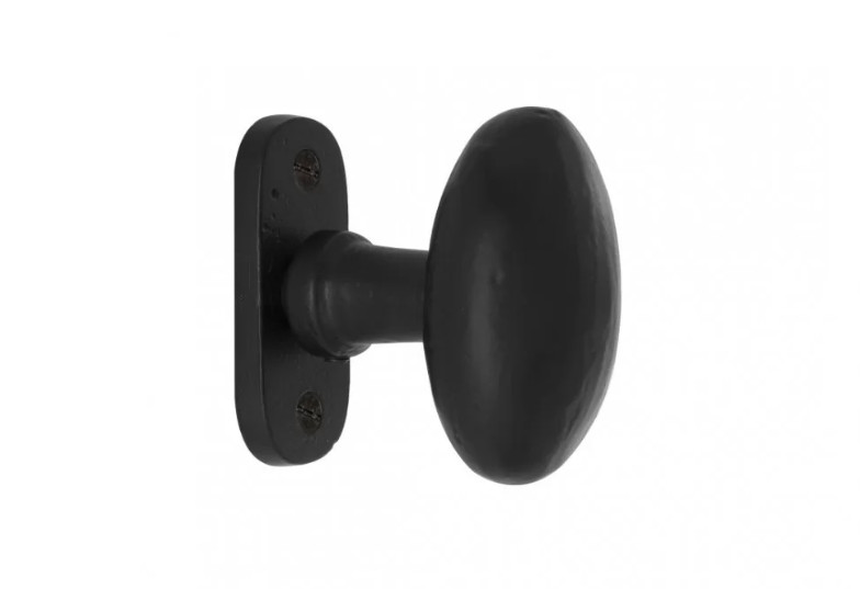 Bouton de porte noir sur plaque carrée installée sur une porte aspect bois foncée
