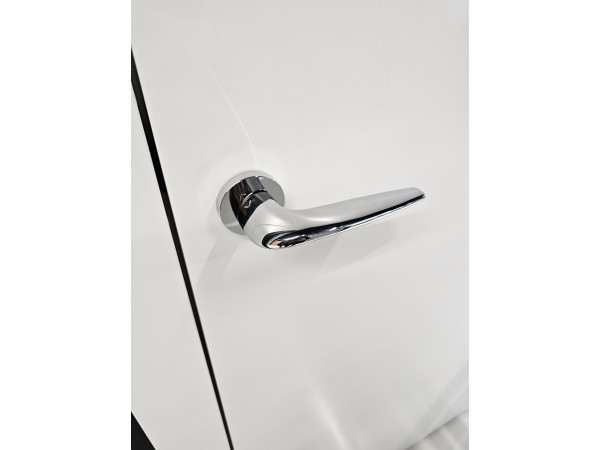 poignée de porte de couleur chrome poli sur une porte blanche