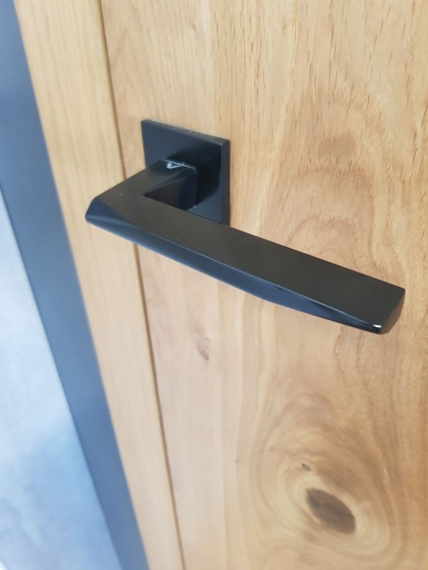 poignée noire design sur une porte en bois