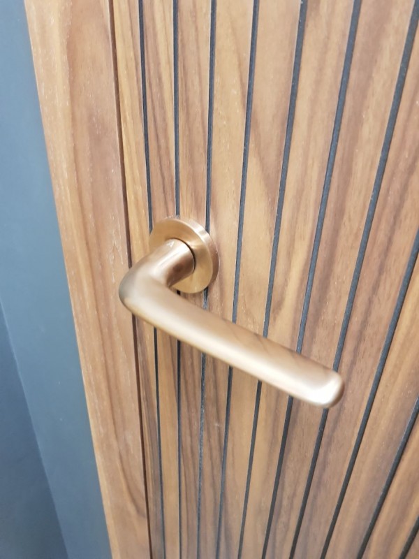 poignée de porte or mat sur une porte en bois